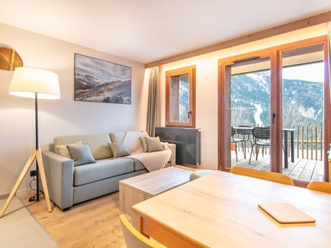 Relax in the inviting living area, with natural light pouring in and a view of the terrace.