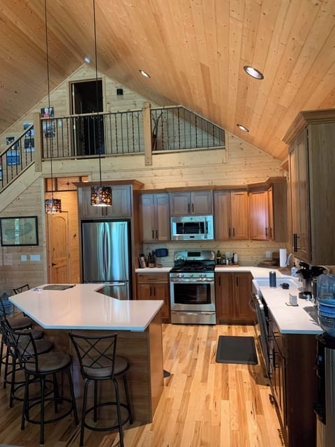 View from dining table area facing upstairs closed loft (sleeps 4) and main full kitchen w/counter-top seating. Main floor has 2 bedrooms and 2 full bathrooms + washer & dryer. (Accurate Illustration, AI Enhanced Decor Due to Build In Progress)