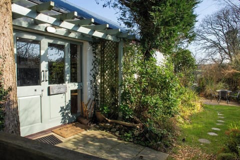 Front entrance with pale green double doors under a pergola