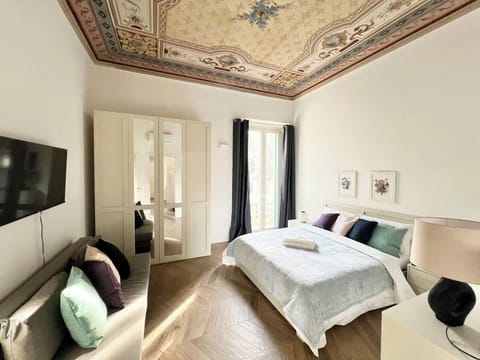 Camera da letto principale con letto matrimoniale, accesso al balcone privato, TV 43", divano-letto a una piazza e mezza, armadio a quattro ante. Climatizzatore sopra la porta di ingresso.