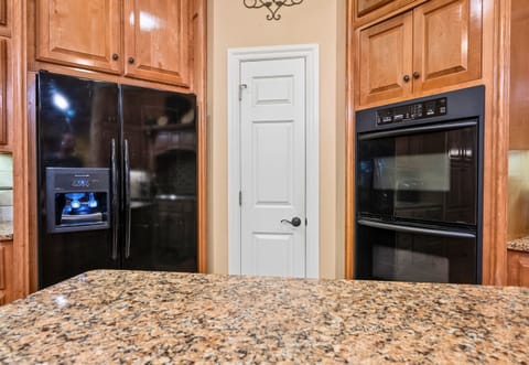 Granite island with plenty of prep space and pantry access.