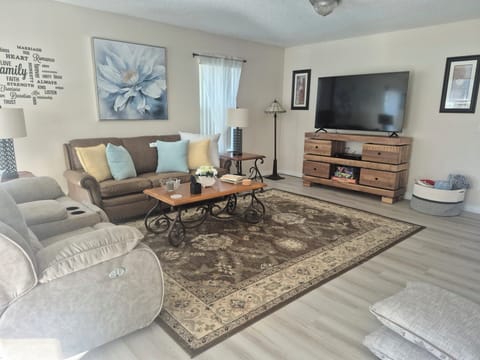 Very large living room with 2 sofas that have 2 reclining seats in each. Large 75 inch tv and nice sunny sitting area at entrance. 