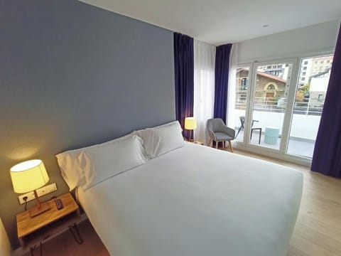 Unwind in a sunlit king bed with balcony breeze.