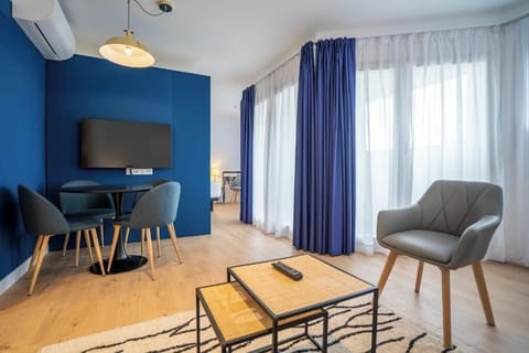 Unwind in a sunlit lounge with cozy seating and TV.