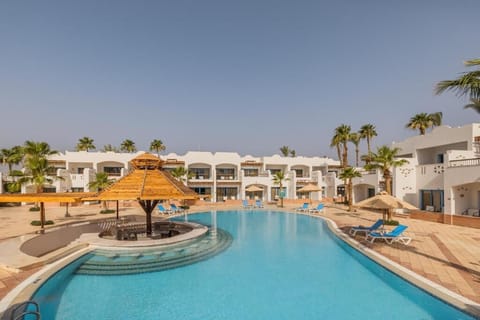 Float peacefully in the expansive pool framed by white villas.