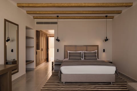 Unwind in a serene king bed under warm wood beams.