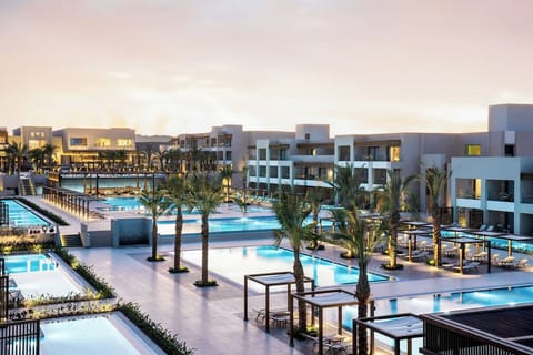 Unwind at sunset beside sparkling pools and palm silhouettes.