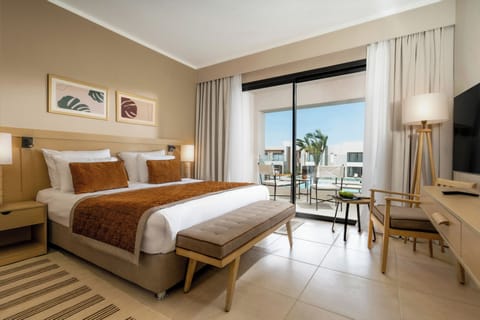 Unwind in a sunlit bedroom with breezy balcony views.