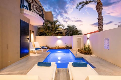 Walled garden pool with palms, perfect for evening relaxation.