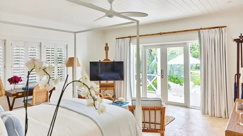 Unwind in airy king comfort with garden-view French doors.