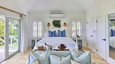 Unwind in crisp, breezy bedroom with tropical views outside.