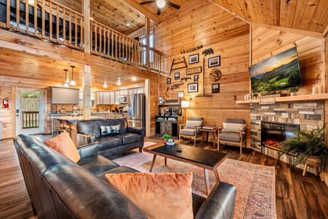 Gather `round in the heart of the cabin. With soaring ceilings, a stone fireplace, coffee bar, and a fully equipped kitchen, this inviting space brings everyone together in comfort and style.