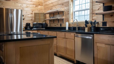 Fully stocked kitchen with stainless appliances and open shelving