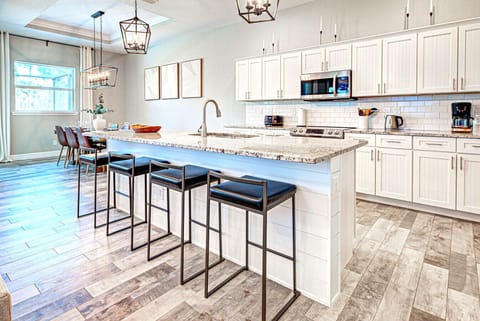 Kitchen with stainless appliances, large granite island that seats 4 with sink in the island