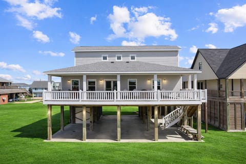 Beautiful elevated beach house in Bolivar Peninsula with spacious wraparound deck, covered parking, and coastal curb appeal near Crystal Beach.