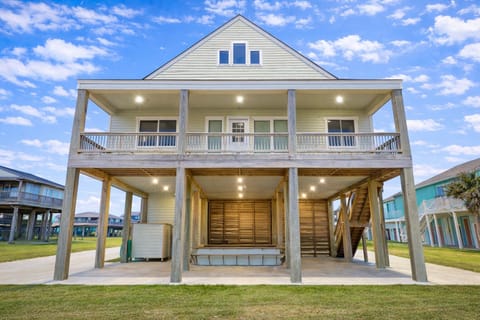 Stunning elevated beachfront home in Crystal Beach, TX featuring spacious covered parking, coastal architecture, and direct beach access—perfect for large group vacation rentals in Bolivar Peninsula.