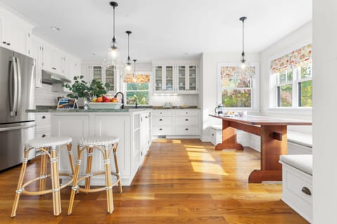 White kitchen with barstool seating and breakfast nook.