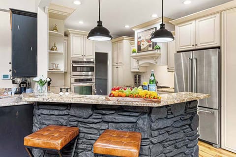 Chef's kitchen with granite countertops, double ovens, and stone island