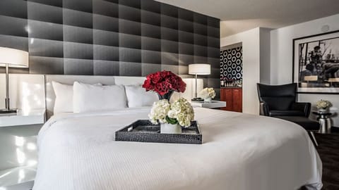 Sink into crisp linens beneath a dramatic, padded headboard.