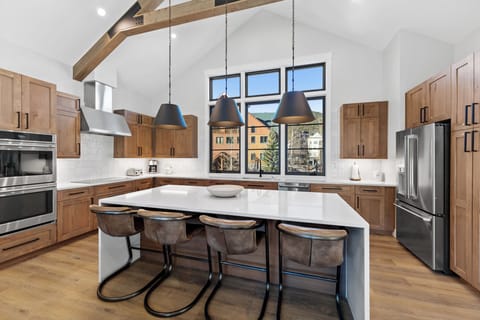 The full kitchen offers stainless steel appliances, including a double oven, and breakfast bar seating 4.