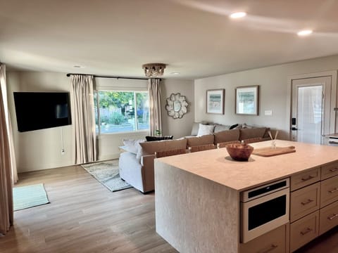 Waterfall Island with seating and view of Comfy Family Room w/ TV.