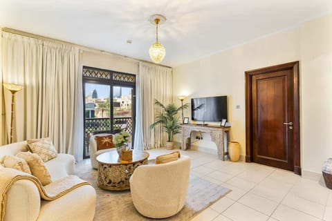 Relax in a stylish and airy living room with balcony access, showcasing the timeless beauty of Burj Khalifa.