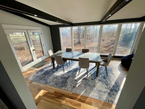 Enjoy meals in the spacious sunroom with a wooded lot as a back drop