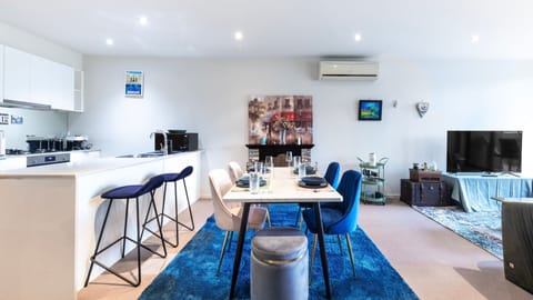 Open-plan living and dining area with stylish blue accents and plenty of natural light.