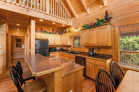 Fully equipped kitchen with stainless steel appliances & bar seating.