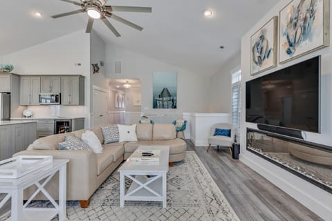 Relax in your bright, open living space with modern fireplace, ceiling fan, and stylish coastal decor creating the perfect home-away-from-home.