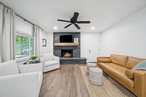 The great room is an open floor plan with with a sofa and two swivel arm chairs.