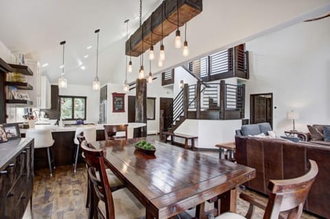 This luxurious dining area features a rustic wooden table and is seamlessly integrated with the modern kitchen, creating a warm and inviting atmosphere.