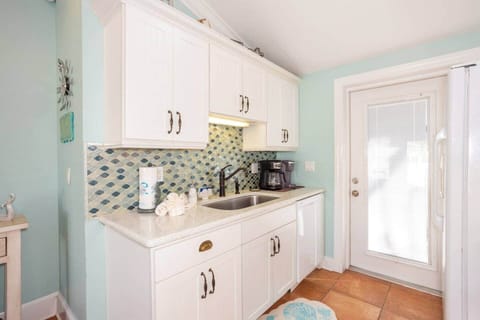 Sunlit open kitchen, beach backsplash, gourmet coffee—Keurig or pot for slow mornings.