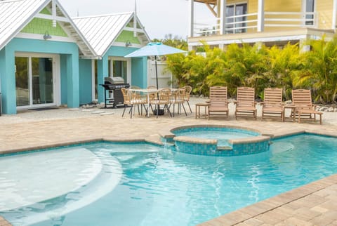 Private heated pool & spa by the AMI villa—palms, loungers, beach steps away.