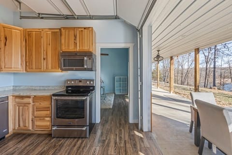 Open kitchen connects to covered porch with peaceful forest views.