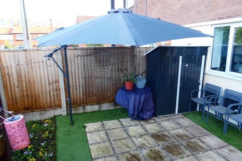 Private outdoor patio area at the front of the property, with garden furniture and parasol.
