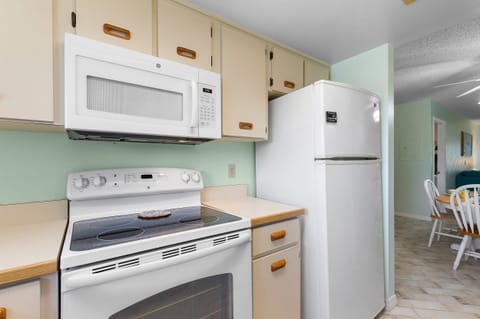 Cook your favorite beachside meals in this fully stocked kitchen featuring modern appliances, bright coastal tones, and easy access to the dining area — perfect for your seaside escape.