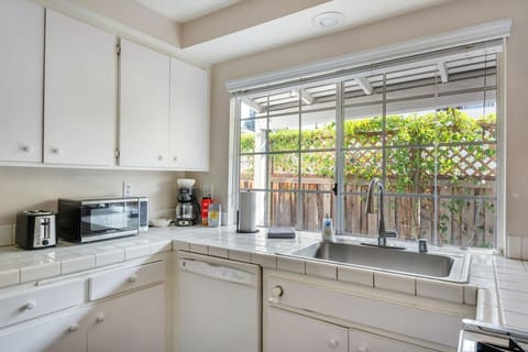 Sunny kitchen with large windows and a view of the private patio.