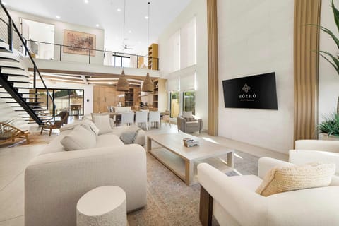 Bright, open-concept living area with soaring ceilings, comfortable seating, and seamless indoor-outdoor living.