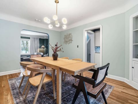 Bright dining room w/ a long wood table, modern chairs & an easy flow for group meals 🍽️✨🏡