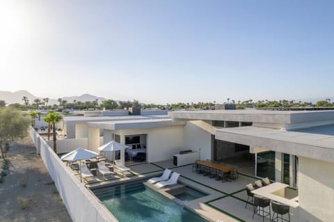 An elevated view showcasing the fully private backyard, pool, dining, and unobstructed mountain views on a clear day.