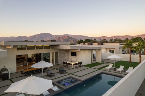 Breathtaking desert views! An elevated view of the entire estate, highlighting the pool, multiple lounge areas, and the stunning Santa Rosa Mountains at sunset.