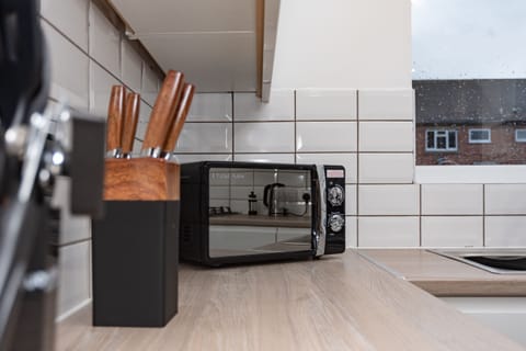Kitchen sideboard stocked with all utensils and a microwave — perfect for quick, on-the-go meals during your stay.