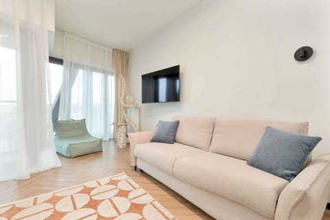 Bright and spacious living room – Modern design with soft tones, large windows, and a comfortable sofa for relaxing.