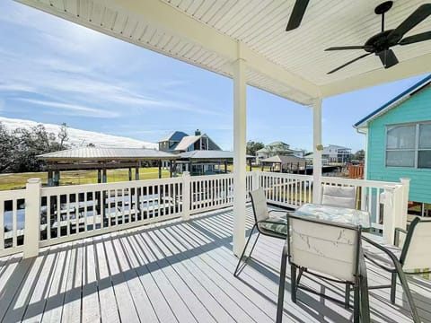 Breezy covered deck with outdoor seating and relaxing neighborhood views—perfect for morning coffee or sunset dinners.