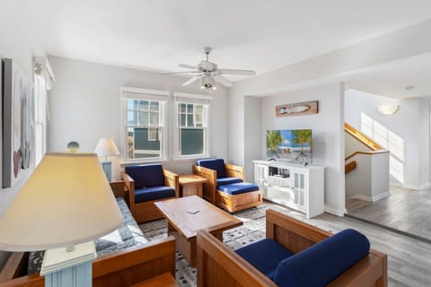 Cozy seating, bright coastal décor, and a TV make the living area perfect for relaxing evenings or family movie nights.