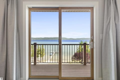 PRIMARY BEDROOM (UPPER LEVEL): The sliding doors going out to the private balcony and the incredible view of Crystal Lake from the bedroom