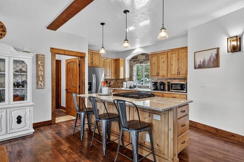Bright kitchen with granite counters and forest-view dining.
