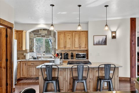 Bright kitchen with granite counters and forest-view dining.