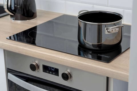 Induction cooktop and appliances – Fully equipped kitchen ready for home cooking.